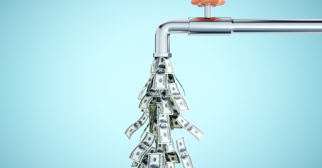 A metal pipe with an orange wheel handle is over a teal background. Hundred-dollar bills flow downward, out of the pipe.